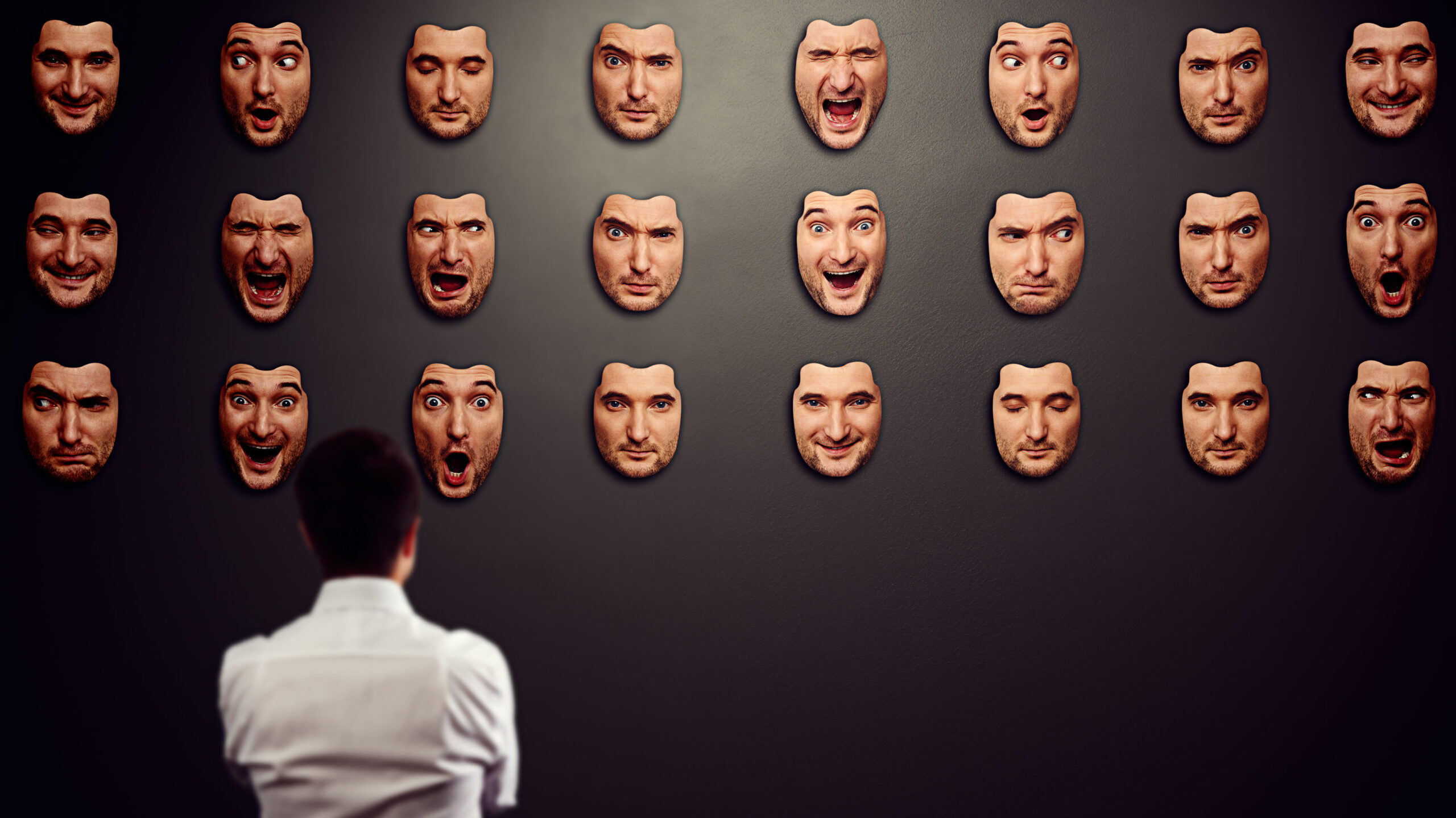 Series of Masks on a Wall with One Mirror: This represents the different facades people with impostor syndrome might feel they need to wear, with the mirror symbolizing the true self that narrative coaching helps reveal. authenticity versus perceived fraudulence.
